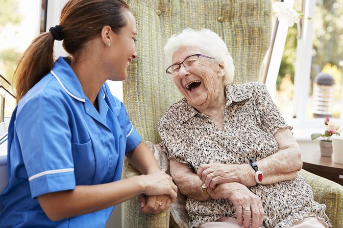 Nurse and older woman laughing