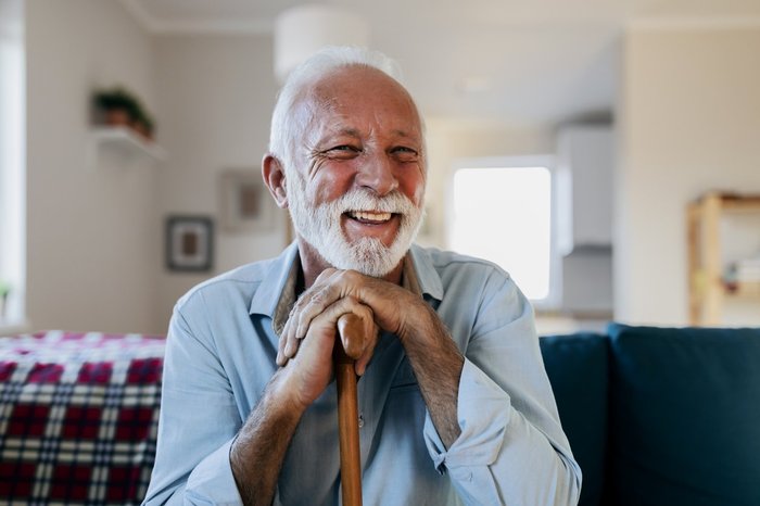 Older man with cane laughing